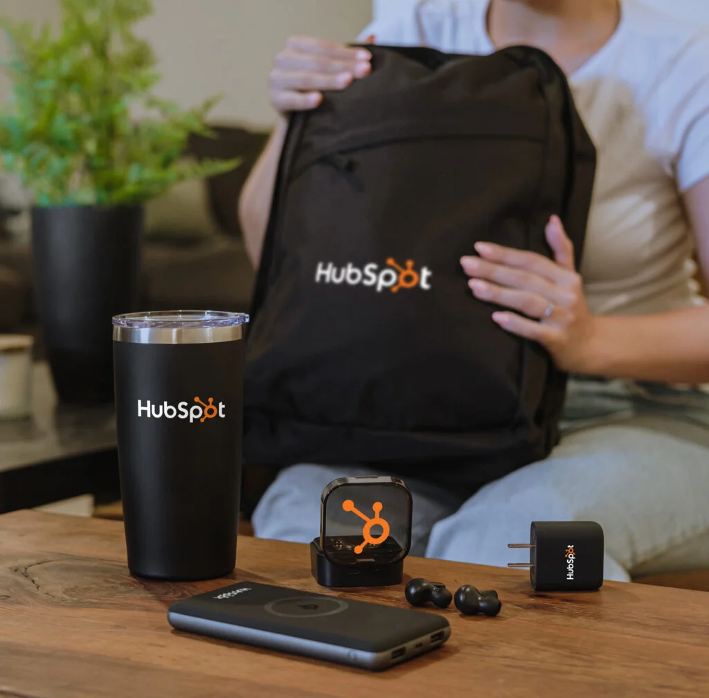 Company onboarding kit with branded backpack, branded tumbler, branded tech gifts.