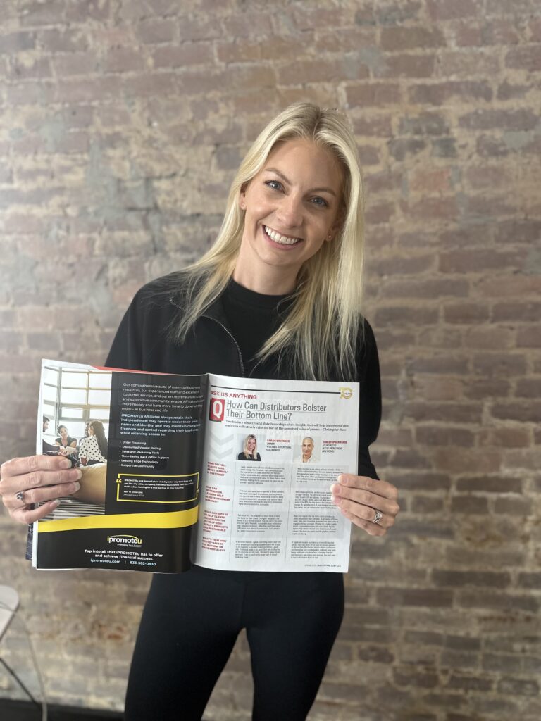 Sarah Whitaker, owner of Williams Advertising, holding up a magazine showing the article that she is featured in.